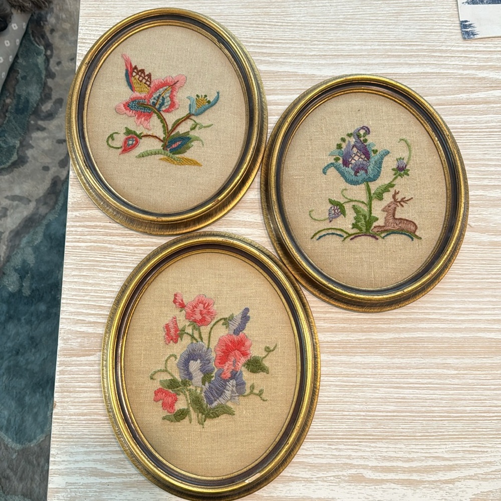 Three needle point round gold frame pictures